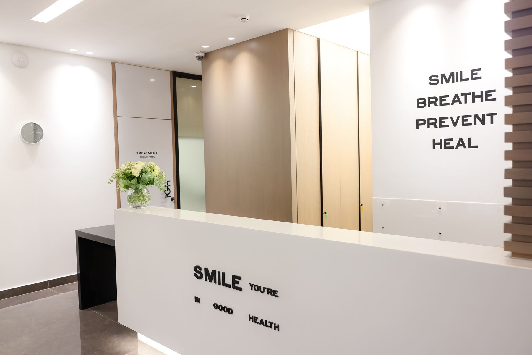 IGH front desk with the wall message: smile, breathe, prevent, heal